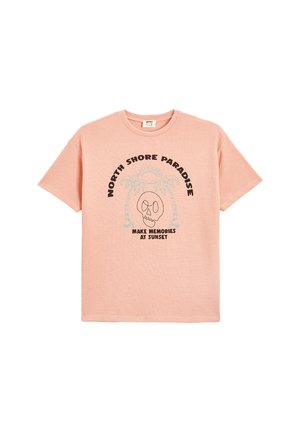 Camiseta de manga corta de color rosa claro con tejido texturizado y diseño impreso que incluye "NORTH SHORE PARADISE" y una gráfica de calavera.
