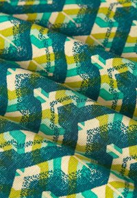 Bomullstyg med en strukturerad väv, med ett geometriskt mönster i turkos, grön och krämfärgad, vilket skapar en visuellt dynamisk yta.