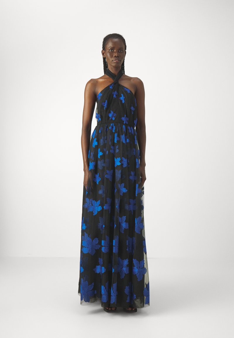 Maxikleid aus durchscheinendem schwarzem Stoff mit blauen Blattmustern. Halterneck-Design und elastischer Bund, fließende Silhouette bis zum Boden.