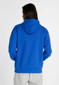 Felpa con cappuccio blu, dotata di tasca a marsupio, polsini e orlo a costine. Realizzata in un tessuto morbido, presenta un design semplice e uniforme.