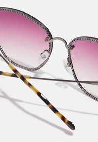 Gafas de sol de gran tamaño con lentes en degradado rosa, montura metálica con un borde texturizado y patillas con patrón de carey.