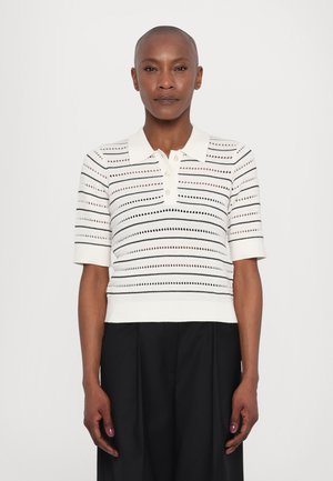 Balts adīts polo tops ar horizontālām melnām svītrām un atvērtajiem rakstiem. Īsas piedurknes un ribota apkakle ar trim pogām.