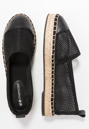 Sorte espadrilles med flade såler, vævet mesh på siderne, læderhætte og flettede jutesåler vist fra top- og sideview.