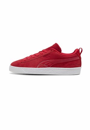 Czerwony niski zamszowy sneaker z białą teksturowaną gumową podeszwą, dopasowanymi czerwonymi sznurowadłami i naszytym logo Puma z boku.
