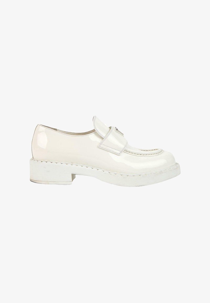 Mocassin en cuir verni blanc avec une semelle épaisse et une large bride sur le dessus, présenté en profil latéral sur fond blanc.
