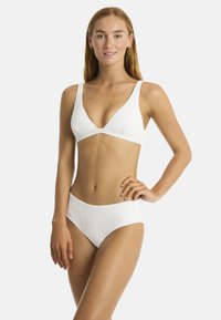 Set bikini bianco composto da un reggiseno triangolare con spalline larghe e pantaloni a vita alta, entrambi con intricati motivi testurizzati.