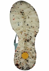 Suola della sandaletta in gomma bianca con una superficie testurizzata e macchie colorate. Logo giallo centrato e diversi solchi di trazione sono visibili.