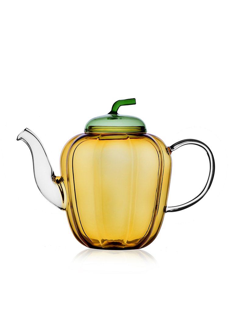 Szklany czajnik w kształcie dyni, z bursztynowym korpusem, przezroczystym dzióbkiem i zieloną pokrywką z małym, zakrzywionym uchwytem.