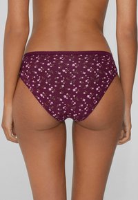 Bikini-Hose mit burgunderrotem Blumenmuster, die ein niedrig geschnittenes Design, weichen Stoff und zarte rosa und grüne Blumenmuster aufweist.