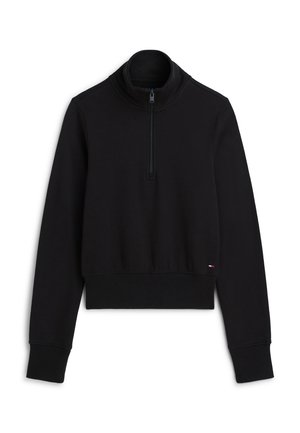 Μαύρο πουλόβερ με μακριά μανίκια και γιακά με φερμουάρ ως τη μέση, με ριμπ μανσέτες και τελείωμα, και μικρό λογότυπο κοντά στη μέση σε λευκό φόντο.