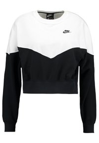Kort svart och vit sweatshirt med ett chevron-mönster, med lång ärm och rundad nacke. Nike-logotyp på bröstet.