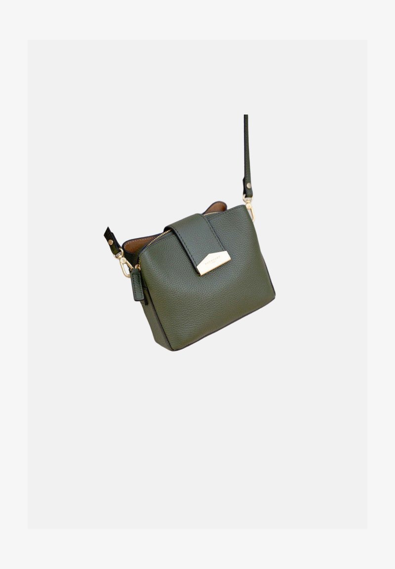 Sac bandoulière en cuir vert foncé avec fermeture éclair dorée, sangle frontale avec étiquette métallique et bandoulière réglable.