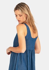 Denim jurk in blauw, met een getailleerde lijfje en een uitlopende rok. Dikke banden en een ronde rugontwerp. Zachte textuur, casual stijl.