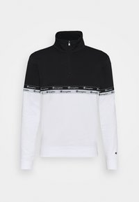 Felpa nera e bianca con zip a ? quarto e una fascia con il logo Champion sul petto. Realizzata in tessuto morbido, presenta maniche lunghe e un colletto alto.