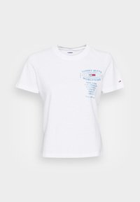 Bílý bavlněný tričko s krátkými rukávy, kulatým výstřihem a modrou potisknutou značkou, která zahrnuje text pro různé města. Klasický střih.