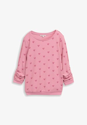 Roze top met lange mouwen, donkerroze hartjespatroon en gerimpelde mouwen, plat gelegd op een witte achtergrond.