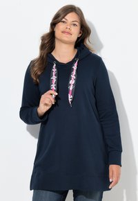 Felpa blu scuro con tasca a manica, dotata di un cordino a motivo rosa e bianco. Delicata, con vestibilità ampia e polsi a costine sulle maniche.