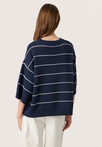 Navy gestrickter Pullover mit hellgrauen horizontalen Streifen, Rundhalskragen und weiten Ärmeln, mit einem gerippten Saum abgeschlossen.