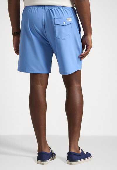Shorts de baie bleu deschis cu un talie elastică și o buzunar pe spate cu închidere tip snap. Asortați cu pantofi din pânză bleumarin.