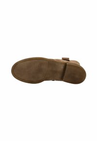 Botte en daim marron vue de la semelle montrant le profil texturé, le talon empilé et le nom de la marque embossé sur l'arche centrale.