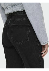 Vaqueros de tiro alto en negro, confeccionados en denim, con dos bolsillos traseros, una textura suave y un diseño de pierna recta.