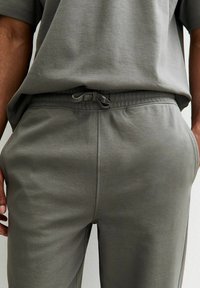 Conjunto de mezcla de algodón gris que incluye una blusa holgada y pantalones con cintura ajustable, con una textura suave y un ajuste relajado.
