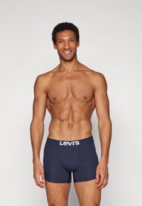 Marineblå Levi's boxertrosor med en vit logotyp på det elastiska midjebandet, med en figurnära design och mjuk textur.