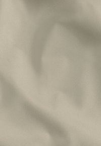 Tessuto beige chiaro con una texture liscia e leggermente lucida, che mostra morbide pieghe e una sottile lucentezza.
