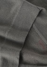 Tissu gris, texture douce, présentant une surface lisse avec un tissage légèrement irrégulier. Les bords visibles sont nets et finis.