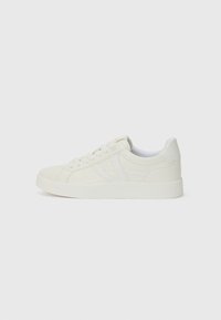 White sneakers with a smooth leather finish, round toe, flat rubber sole, and subtle seam detailing on the sides. Laced design.