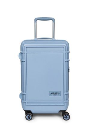 Valigia rigida azzurro chiaro con manico telescopico, quattro ruote girevoli e logo Eastpak al centro davanti.