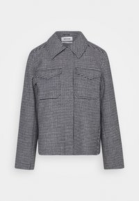 Czarna i biała kurtka w wzór houndstooth z wyłogami, dwoma przednimi kieszeniami i długimi rękawami. Tkanina ma teksturowane wykończenie.