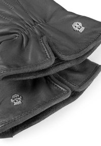 Schwarze Lederhandschuhe mit strukturiertem Finish, gerafften Nähten und silbernen Totenkopf-Logostichen am Handgelenk.