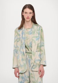 Lightweight, patterned blazer with palm leaf design in soft greens and blues. Features wide lapels and two front pockets, paired with a matching top.