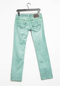 Jeans verde menta con un ajuste slim, que cuentan con bolsillos traseros con un patrón de costura decorativo y una etiqueta de cuero en la cintura.