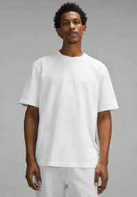 Vit bomull t-shirt med korta ärmar, rund hals, avslappnad passform. Slät textur, enkel design, inga synliga mönster eller detaljer.