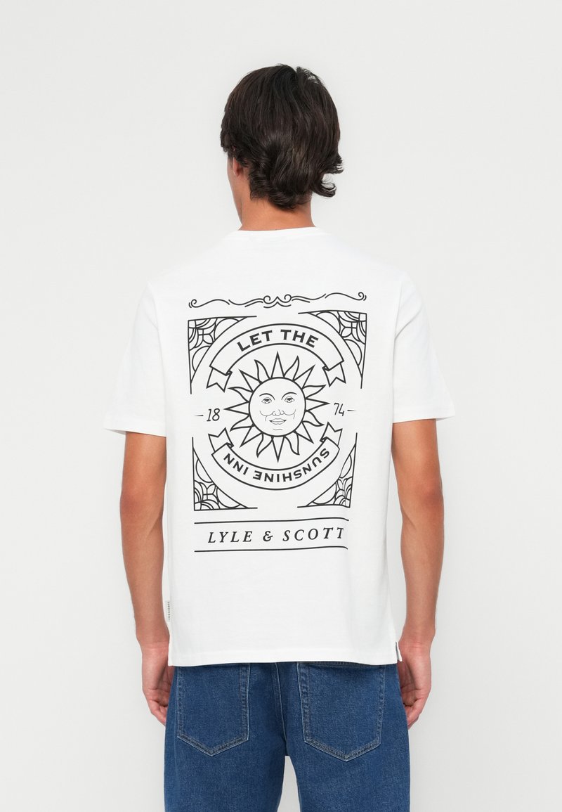 T-shirt blanc à manches courtes présentant un design graphique noir d'un soleil et du texte au dos. Le matériau semble être en coton ; coupe classique.
