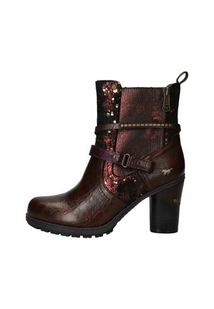 Donkerbruine leren enkellaars met blokhak, decoratieve riempjes, rits en rood glinsterend stoffen paneel met metalen studs aan de zijkant.