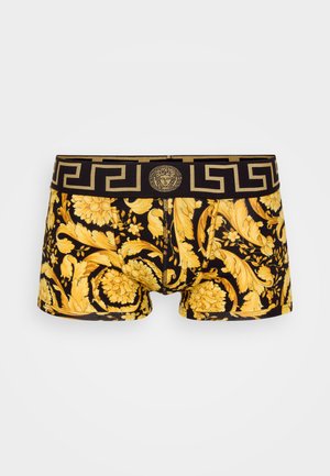 Svart boxershorts med et gullblomstermønster. Har en dekorativ midjebånd med gresk nøkkeldesign og et medaljonglogo foran.