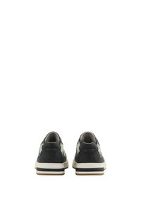 Adidași cu un design elegant, având un exterior albastru închis, accente crem, guler căptușit și o talpă din cauciuc texturată.