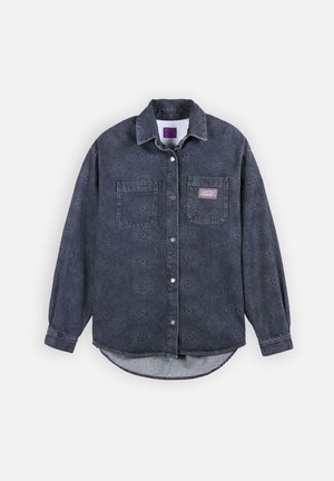 Chemise boutonnée gris foncé avec des motifs floraux subtils, deux poches poitrine et un petit patch logo rectangulaire sur la poche droite.