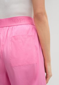 Roze shorts met een elastische tailleband met de opdruk "JOOP!". Inclusief een achterzak met bijpassende roze stiksels. Gladde stoftextuur.