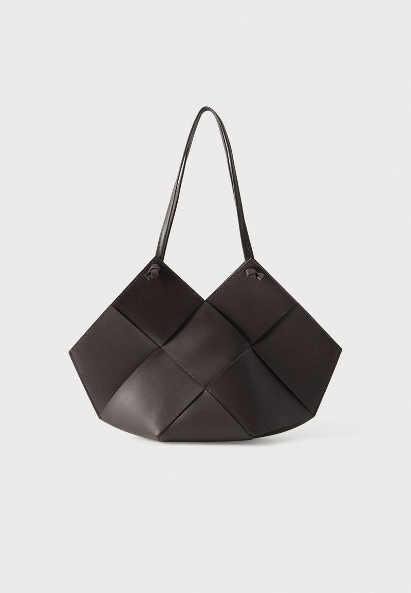 Sac fourre-tout en cuir noir tressé avec un large motif en losange et deux fines bandoulières, présenté sur un fond blanc.