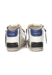 Sneakers alte in pelle bianca con accenti blu, tacco in gomma nero, lacci grigi e cerniere ai lati. Suola testurizzata, dettagli minimi.