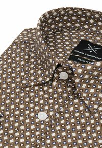 Brąszo-kolorowa koszula w geometryczne wzory w kolorze kremowym i niebieskim. Posiada slim fit, zapięcie na guziki z przodu oraz klasyczny kołnierzyk. Widoczne białe guziki.