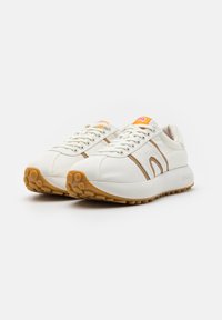 Λευκά παπούτσια με μπεζ λεπτομέρειες και υφασμένο καουτσούκ σόλα. Διαθέτουν στρογγυλά κορδόνια και μικρό λογότυπο στη γλώσσα. Λείου δέρματος επάνω μέρος.