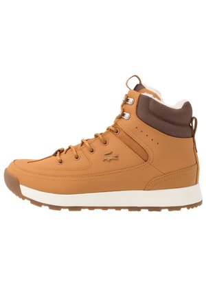 Baskets montantes couleur tan avec col rembourré marron, semelle blanche, fermeture à lacets à l'avant et petit logo crocodile sur le côté.