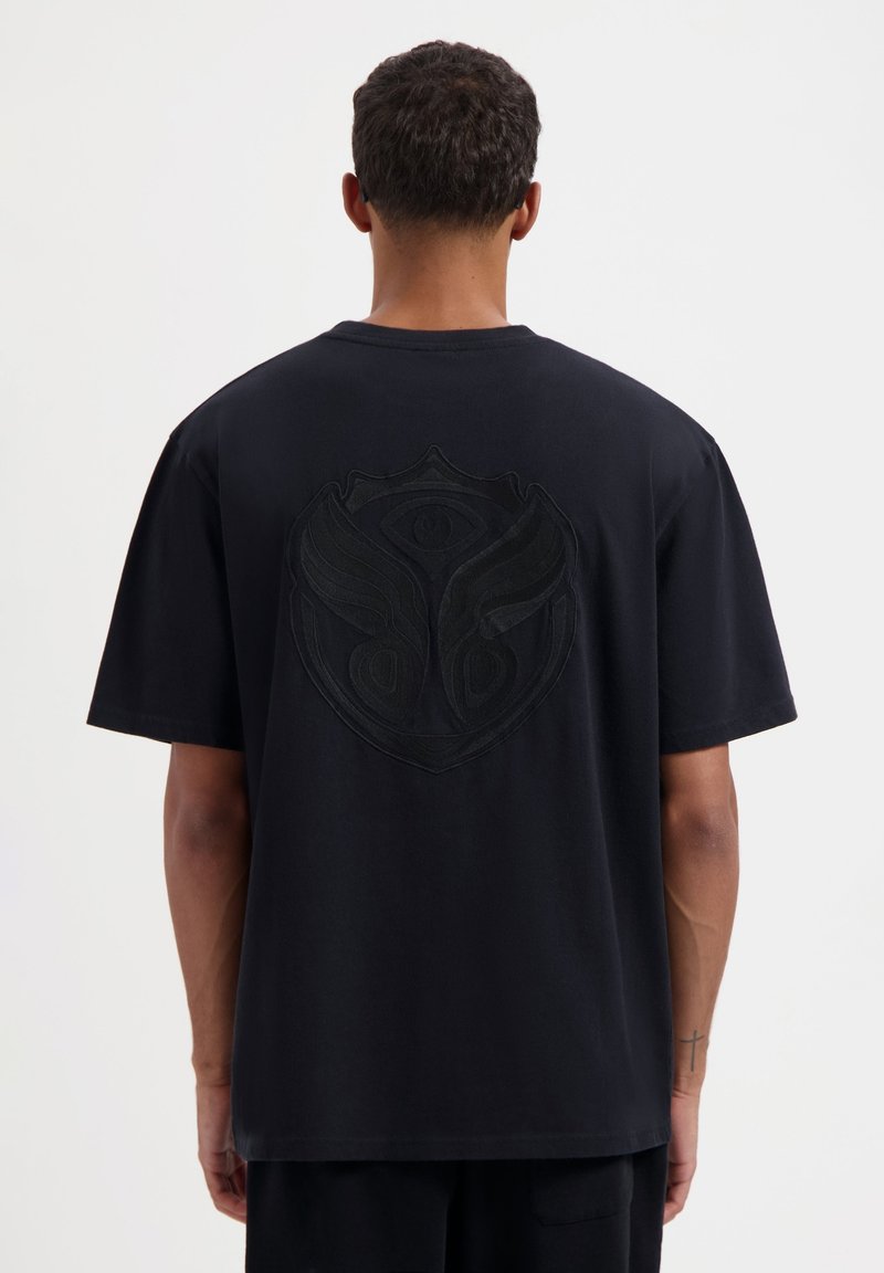 Zwarte katoenen T-shirt met korte mouwen, met een reliëf grafisch logo op de rug. Regular fit met een ronde halslijn, minimale textuur.