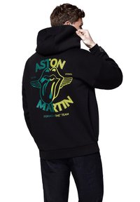 Czarna bluza z kapturem z graficznym nadrukiem w postaci ust i języka w kolorze zielonym i żółtym, z napisem "ASTON MARTIN" i "ROLLING STONES".