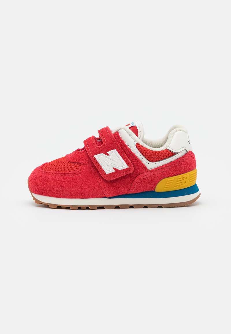 Baskets rouges pour tout-petit avec bande velcro, logo "N" blanc, panneaux en maille et daim, accent jaune au talon et semelle en caoutchouc sur fond blanc.